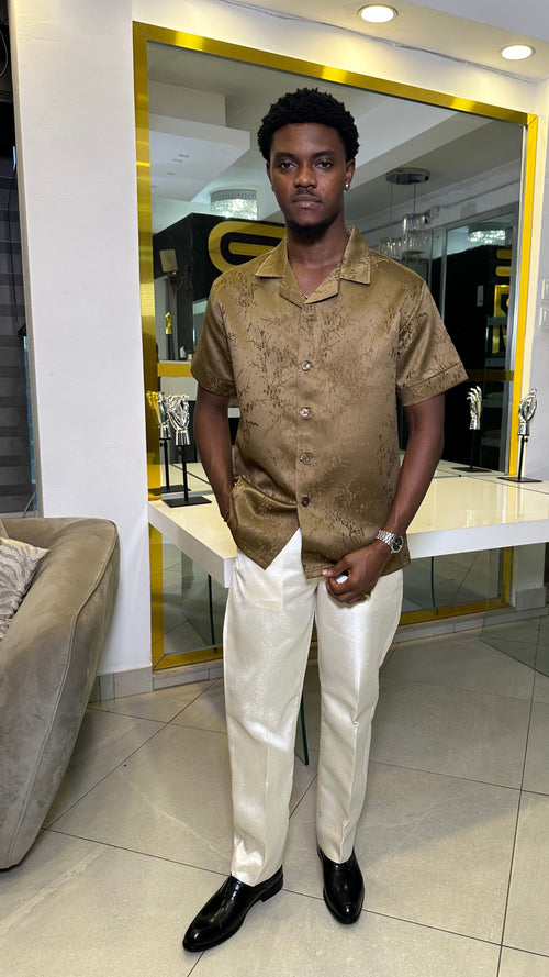 Man wearing a bronze jacquard short-sleeve shirt with ivory tailored trousers from Perfect Mann's premium two-piece occasion collection