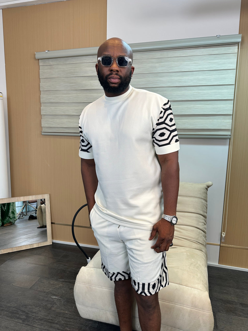Man wearing a white textured two-piece co-ord shorts set with black patterned sleeve and hem details by Perfect Mann